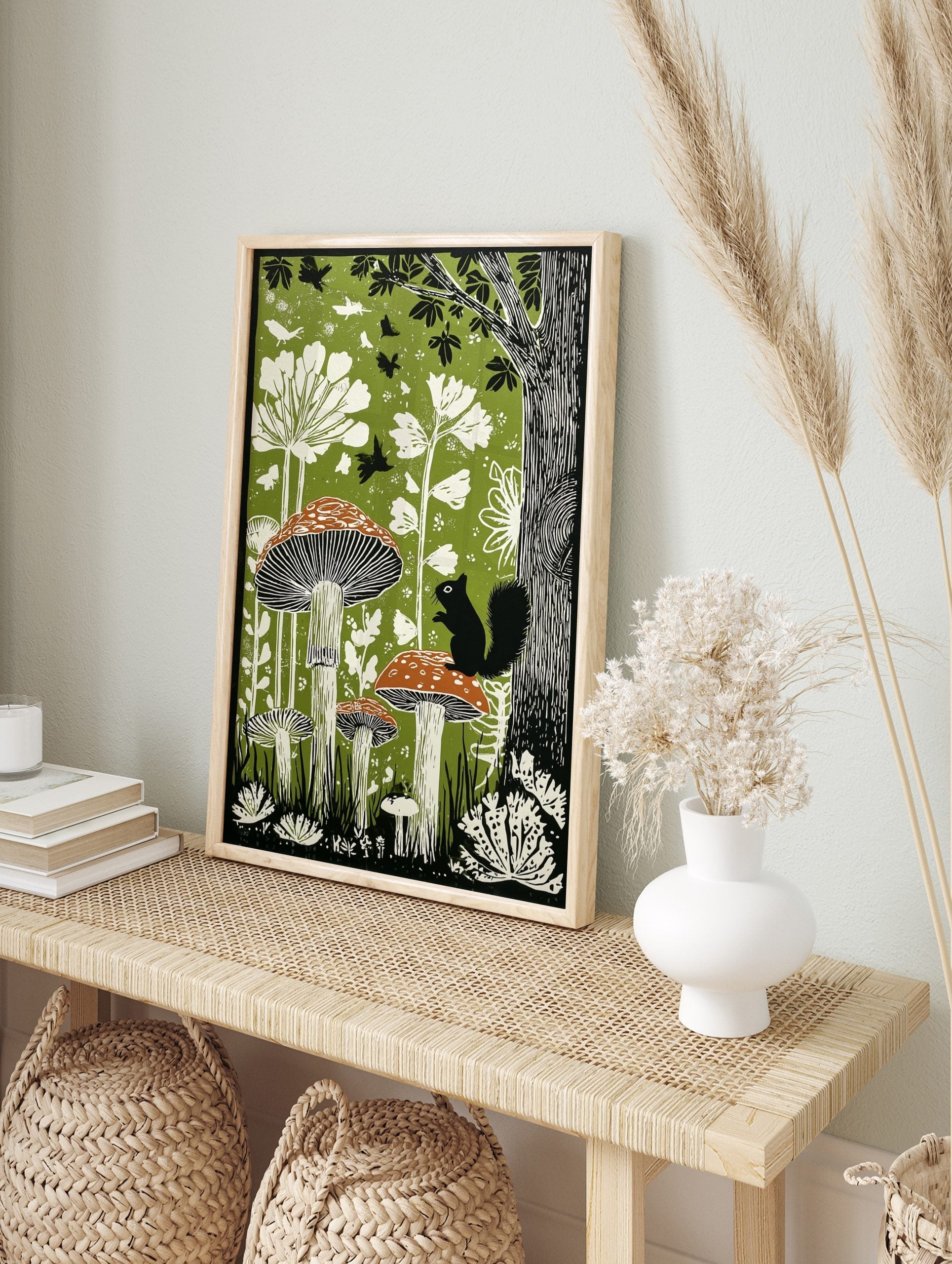 Illustrative green forest print with black squirrel on spotted mushroom and white plants, in an alternate framed mockup