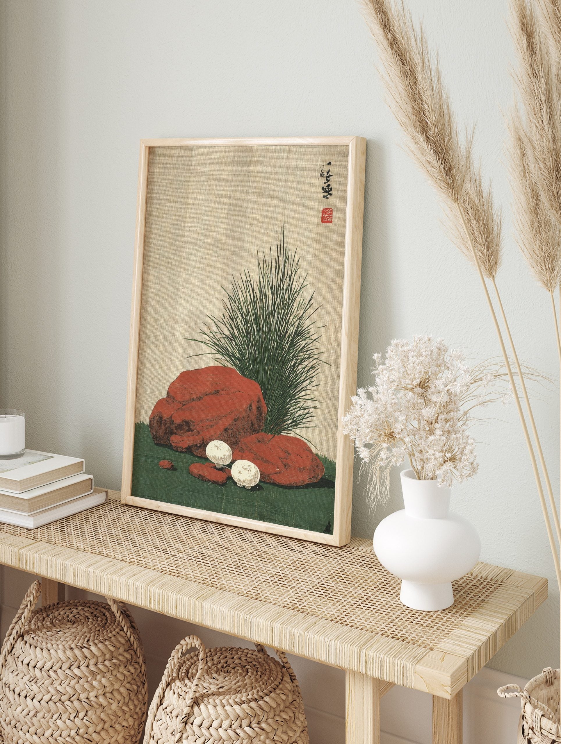 Japanese still life print of white mushrooms, reddish-brown rocks, and green grass on a, in an alternate framed mockup