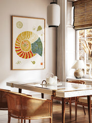 Nautilus shell illustration with orange, yellow, and blue geometric patterns on a white paper, in a styled room mockup