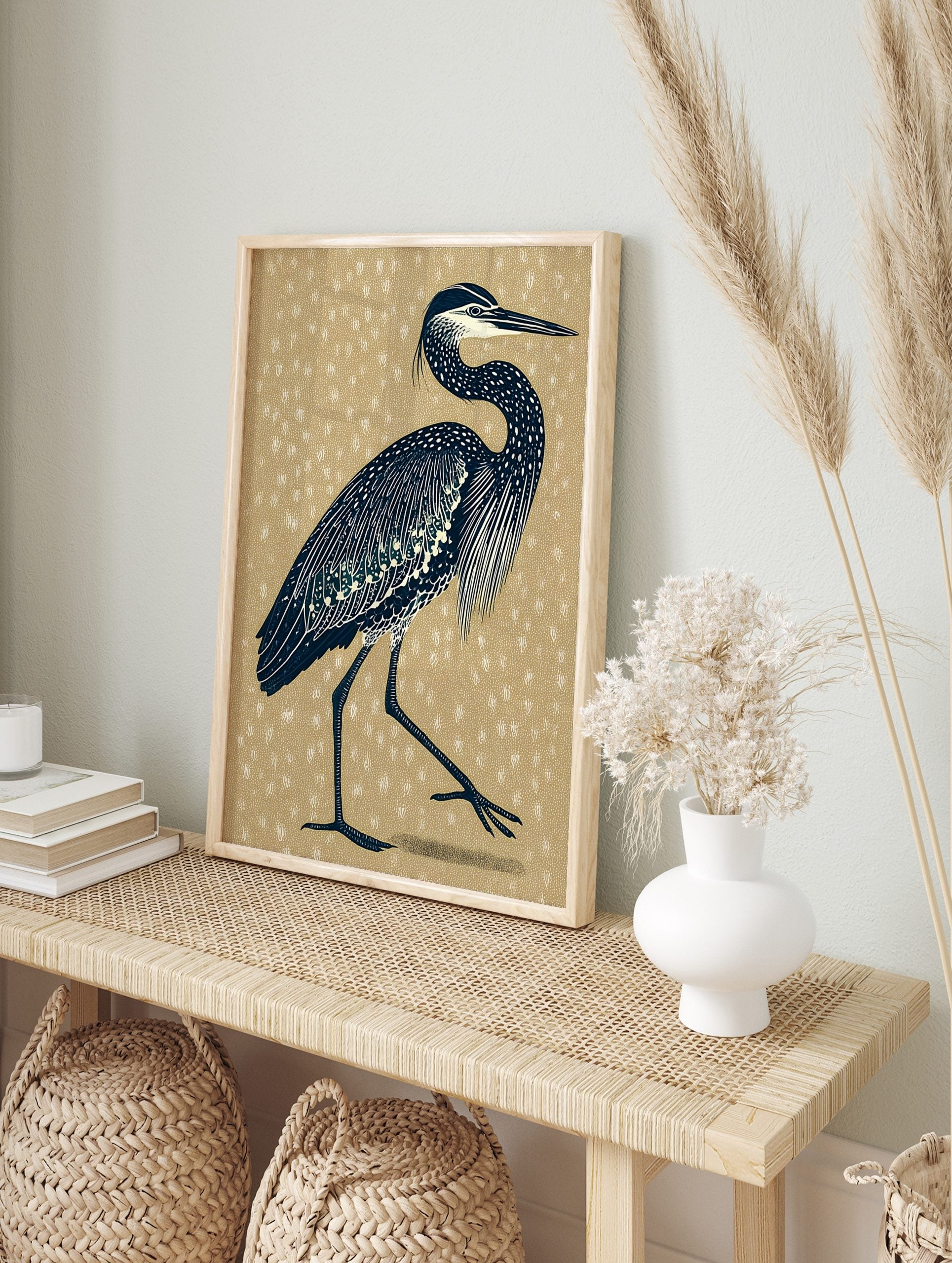 Illustrative navy heron bird print with white details on a textured beige background, in an alternate framed mockup