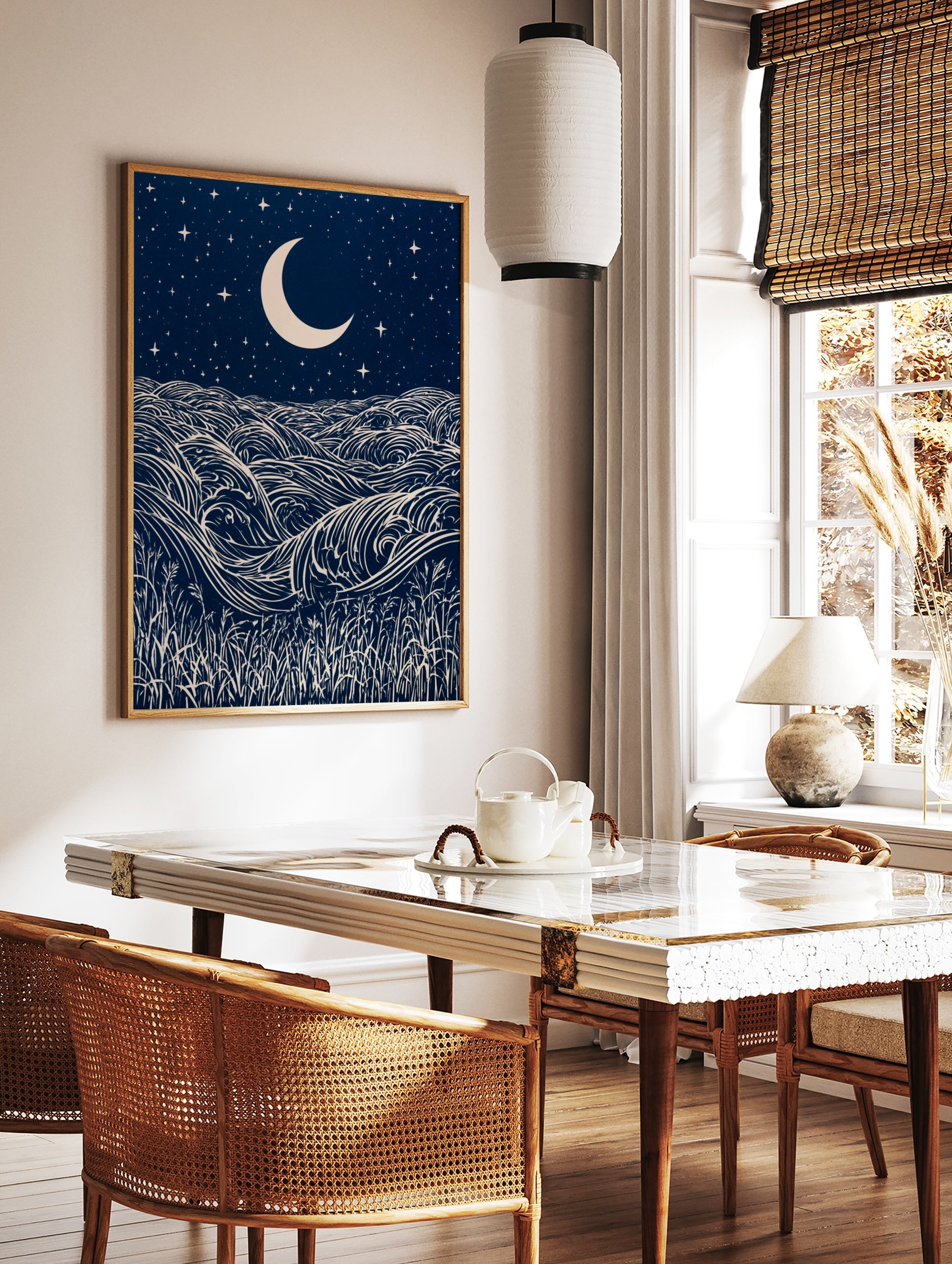 Stylised night ocean illustration with swirling waves, a crescent moon, stars, and grass, in dark, in a styled room mockup