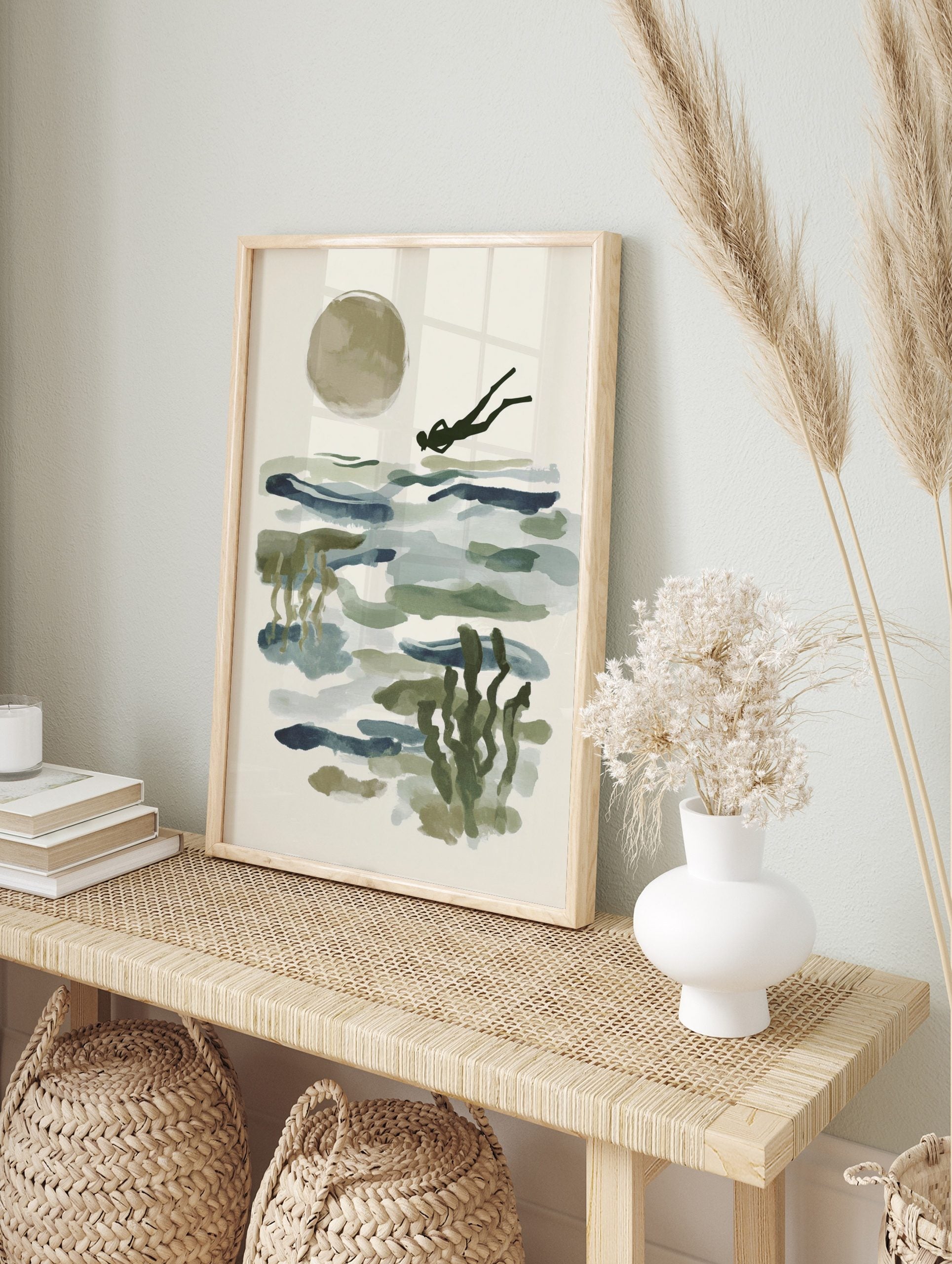 Abstract ocean diver swimming over blue-green water with a large beige sun and underwater, in an alternate framed mockup