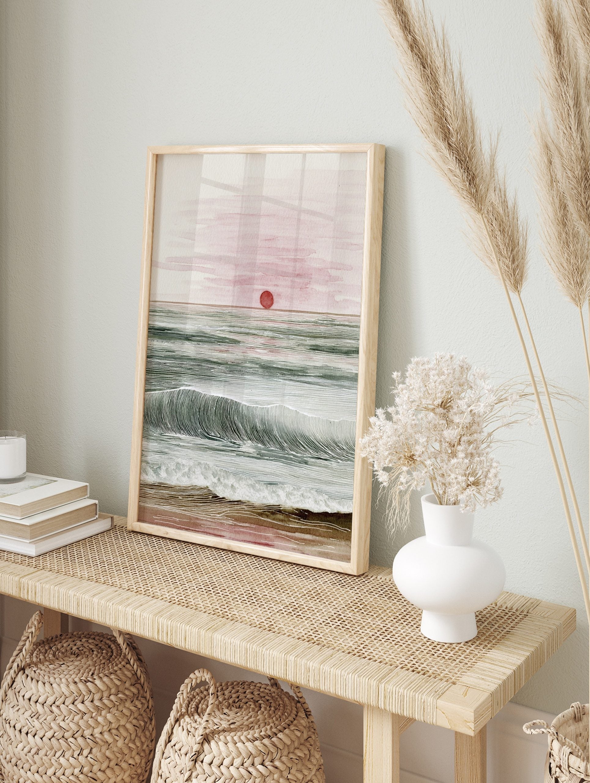 Ocean sunset watercolour and line art print with red sun, green waves, and sandy beach, in an alternate framed mockup