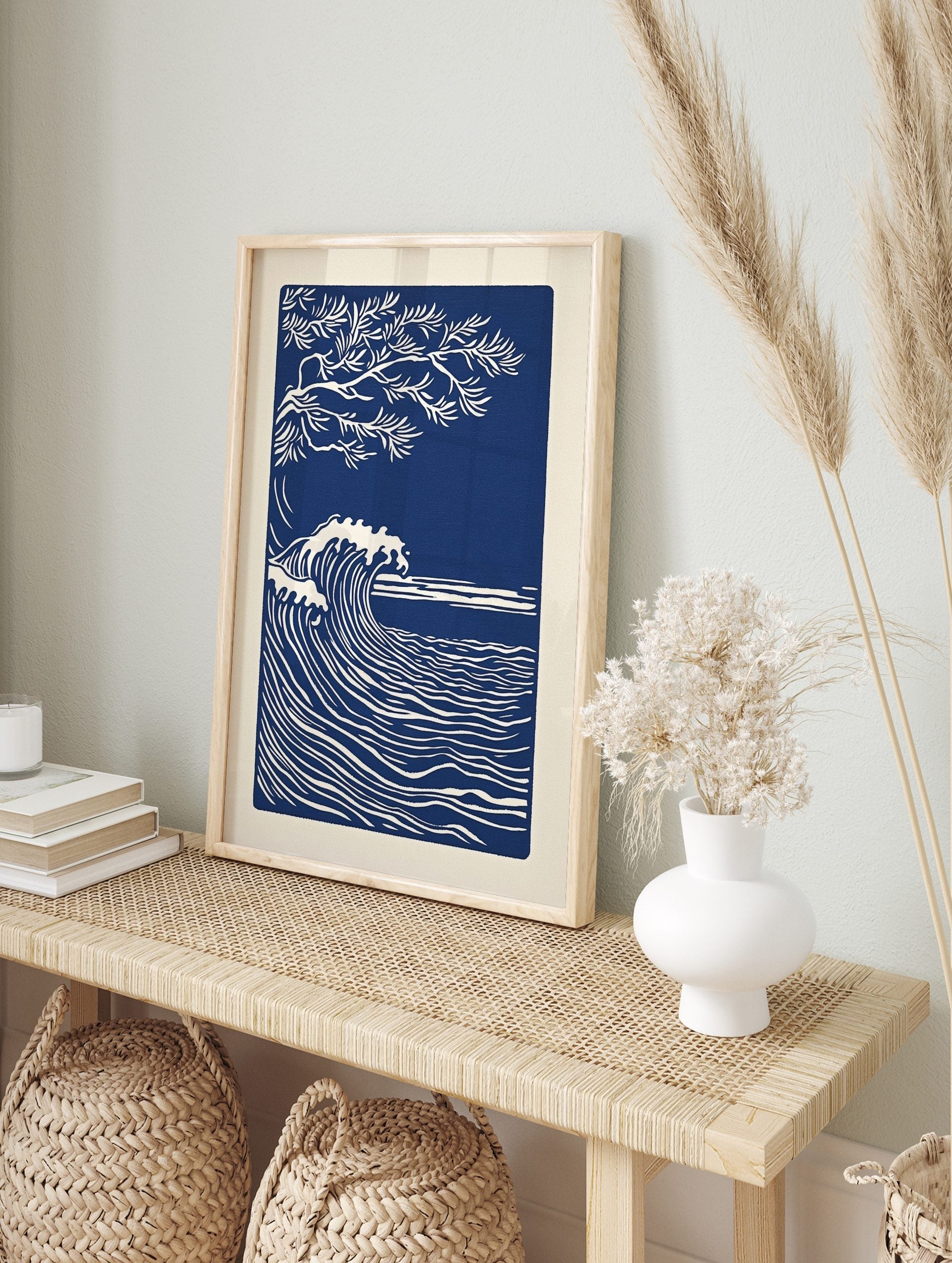 Illustrative deep blue and white art print of a large ocean wave and a tree branch, in an alternate framed mockup