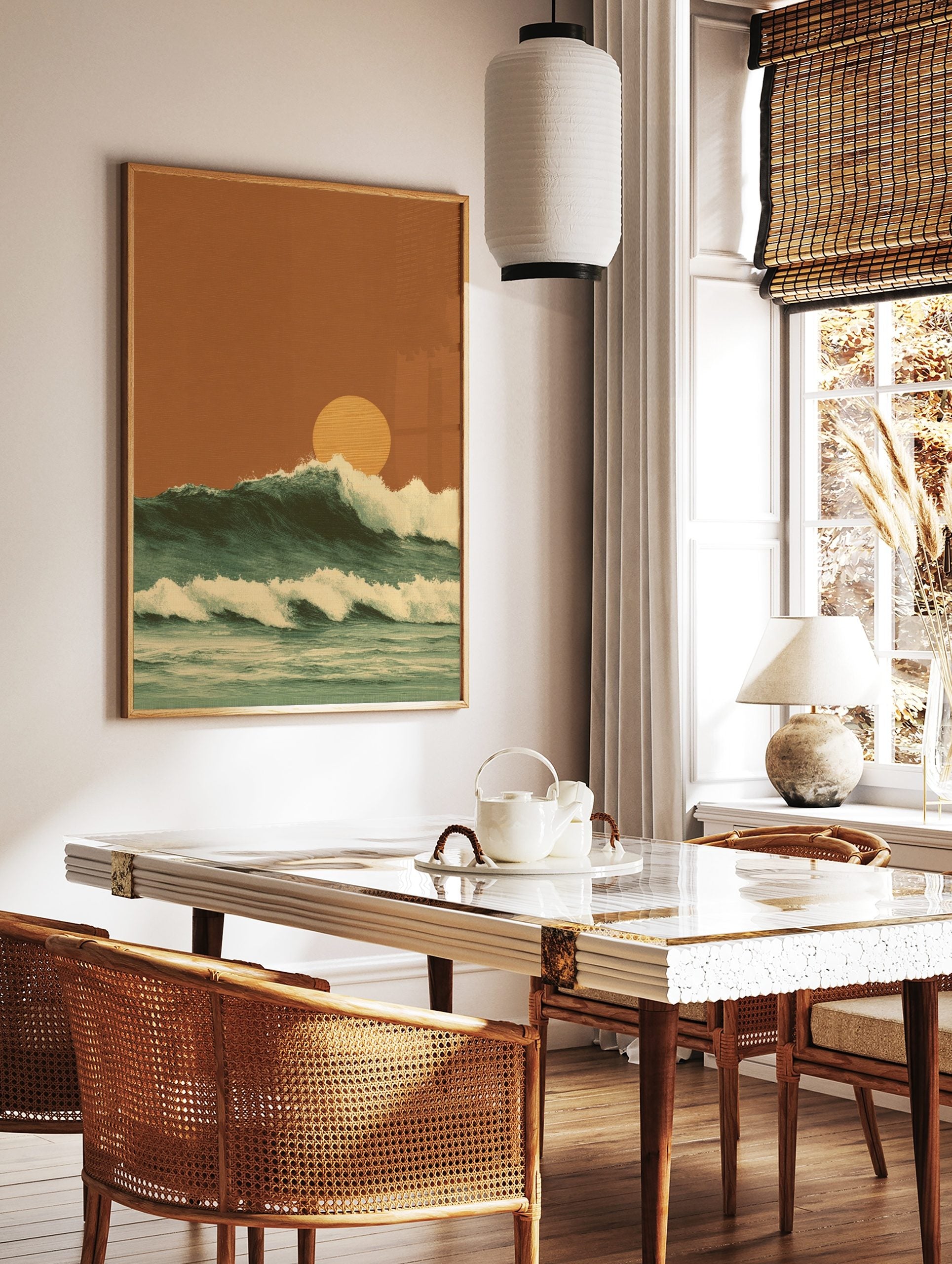 Illustrative ocean waves with white foam crests and a large orange setting sun against an earthy sky, in a styled room mockup