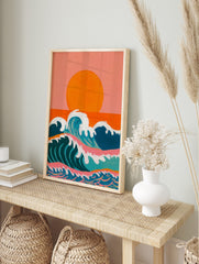 Illustrative ocean waves with white foam under a large orange sun and peachy-pink sky, in an alternate framed mockup