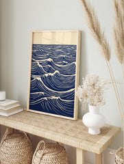 Stylised blue and white lino print of ocean waves with foam crests extending to the horizon, in an alternate framed mockup