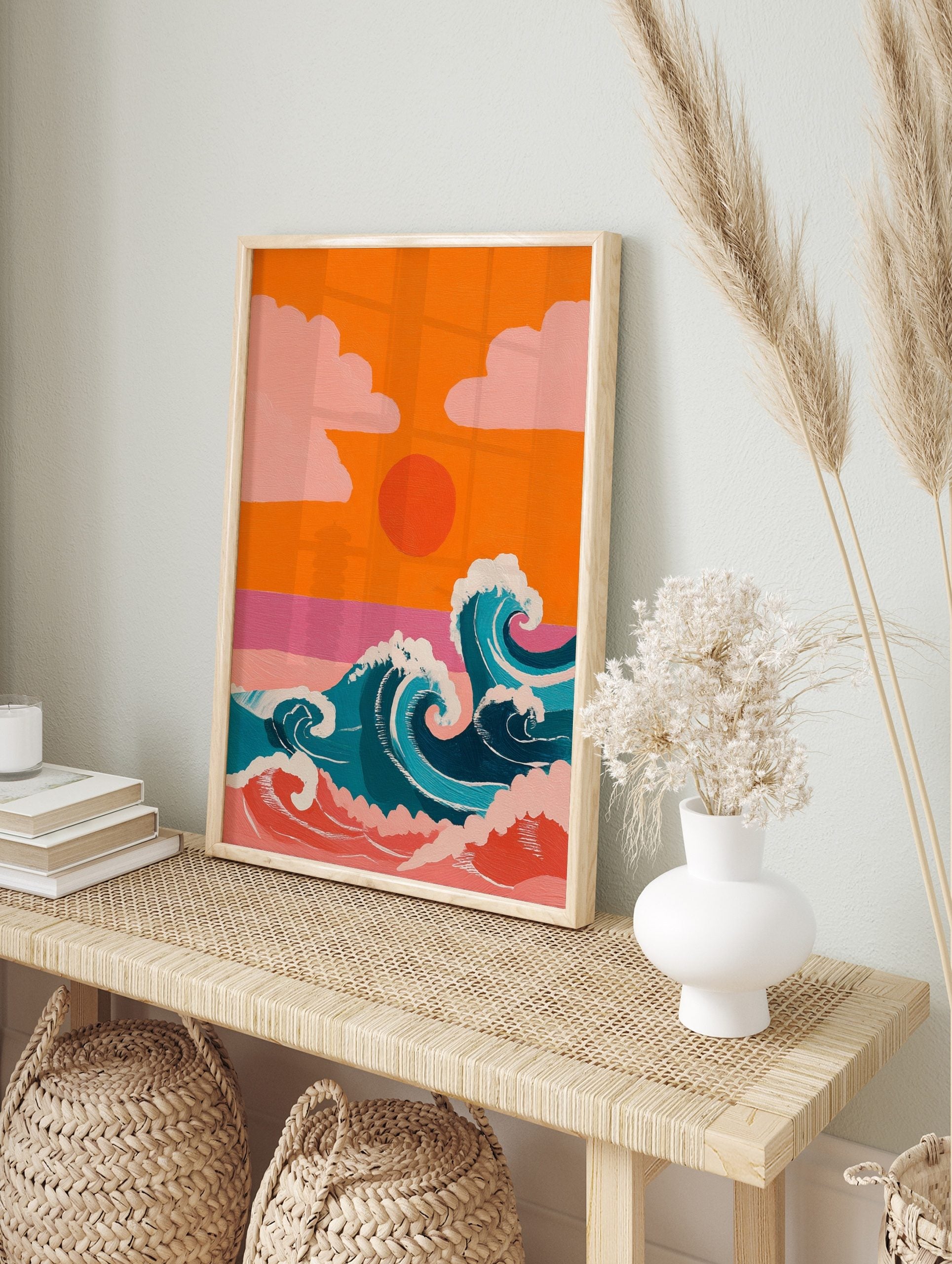 Illustrative ocean waves with white foam, orange sunset, and pink clouds against an orange sky, in an alternate framed mockup