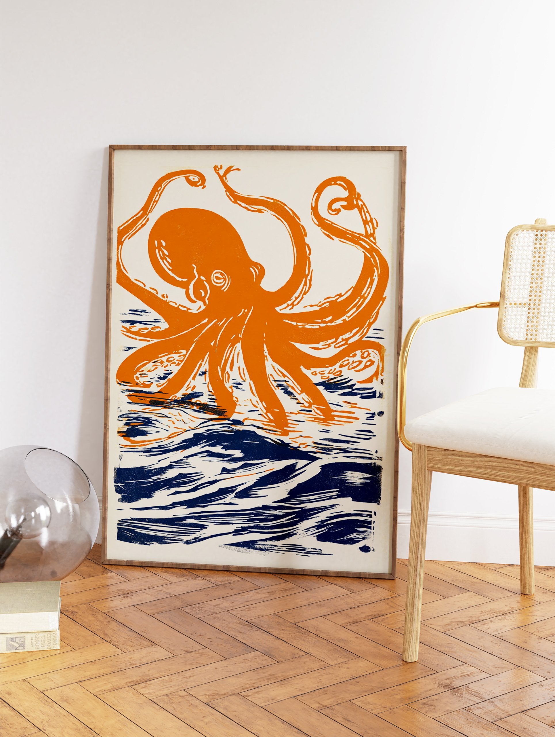 Orange octopus wall art print with dark blue ocean waves on a cream background, illustrated in a linocut style. - Image 2