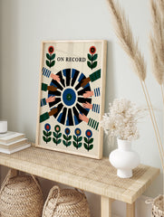 On Record wall art print showing a vinyl record held by multiple hands with floral motifs in, in an alternate framed mockup