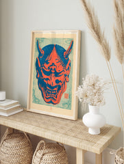 Japanese Oni mask illustration in bold red and blue colours, featuring sharp horns and bared, in an alternate framed mockup