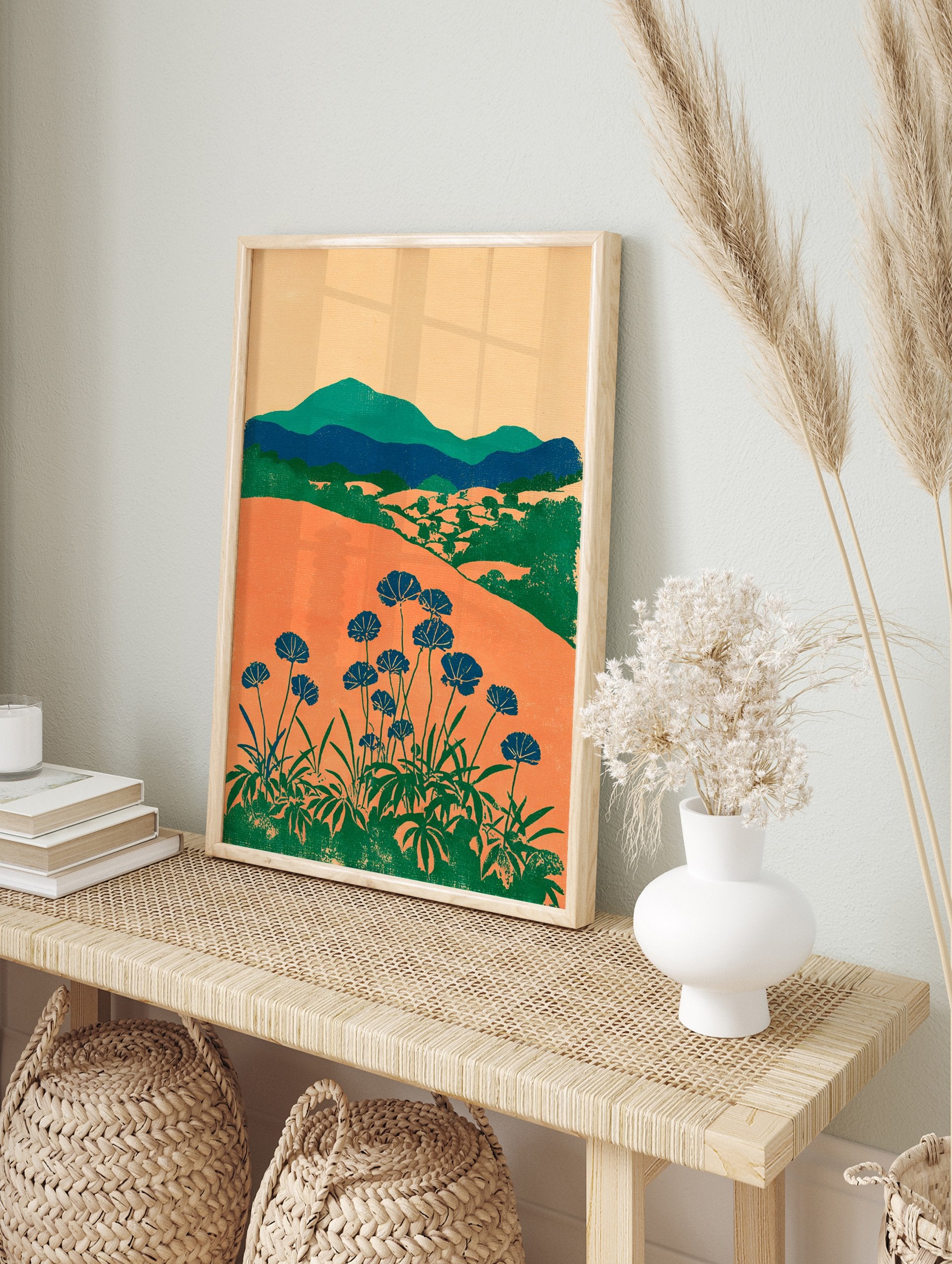 Modern botanical wall art print with orange fields, green mountains, and blue flowers on long stems against a light background. - Image 3