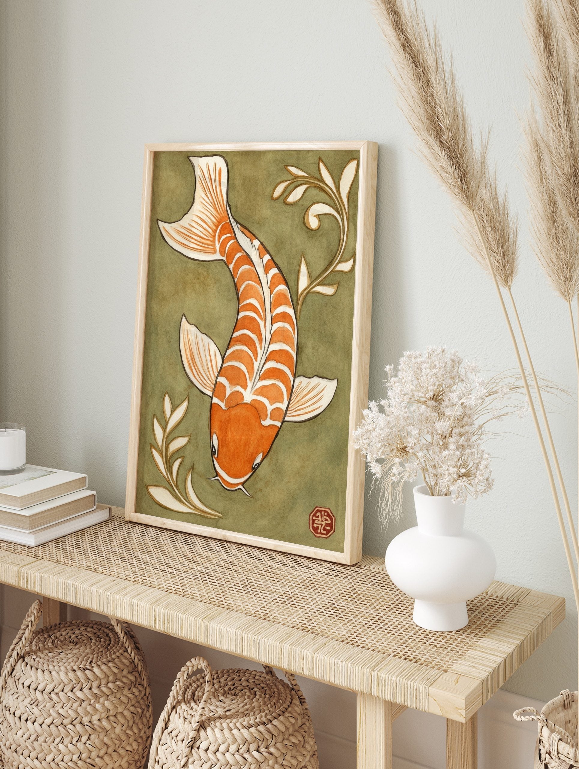 Orange and white koi fish illustration with white plant motifs on an olive green background, in an alternate framed mockup