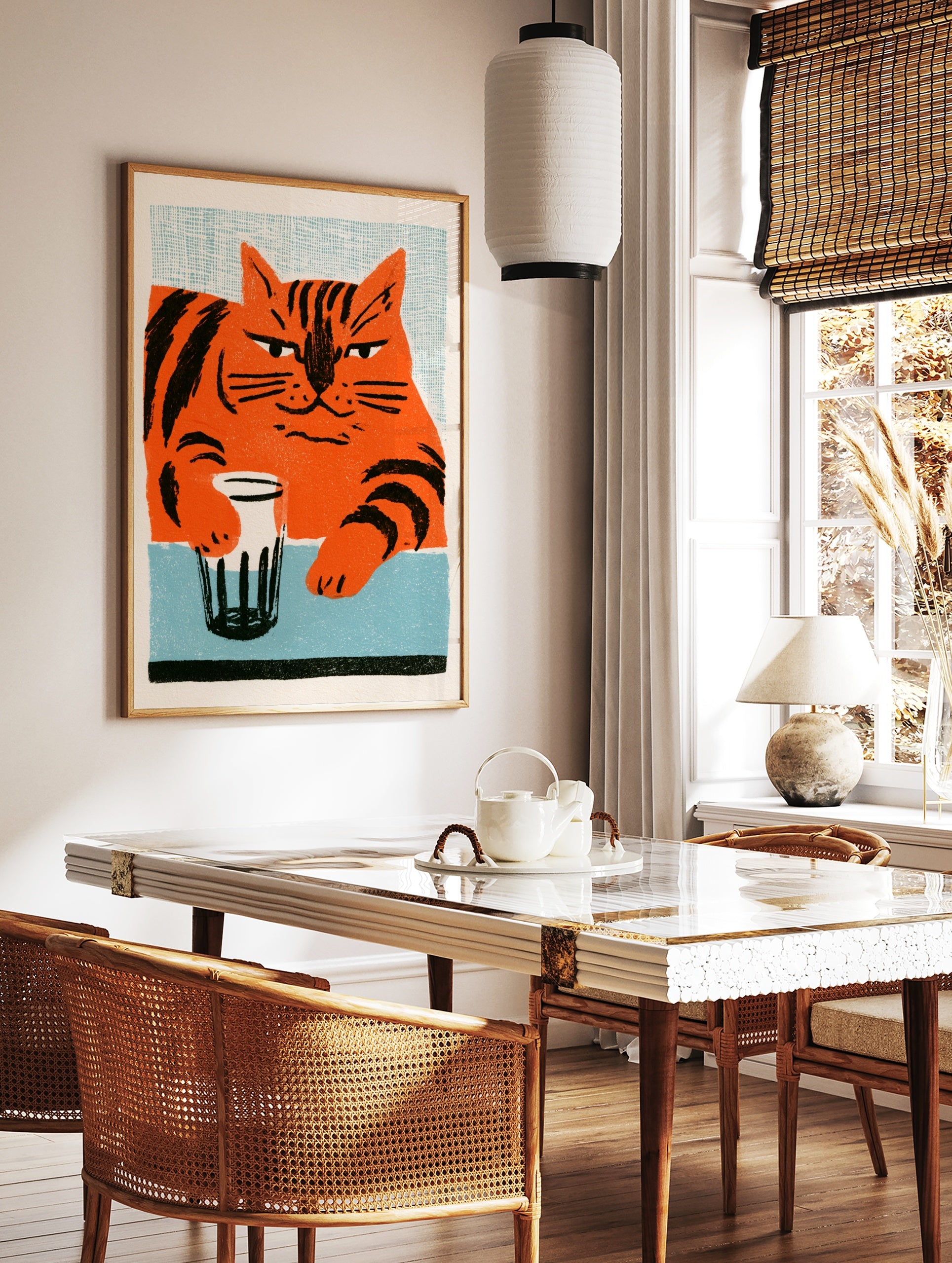 Stylised orange cat with black stripes holding a glass on a blue table, illustrative wall art print, in a styled room mockup