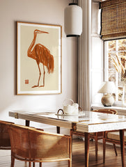 Minimalist orange crane bird illustration with Japanese-style brush strokes on a cream background, in a styled room mockup