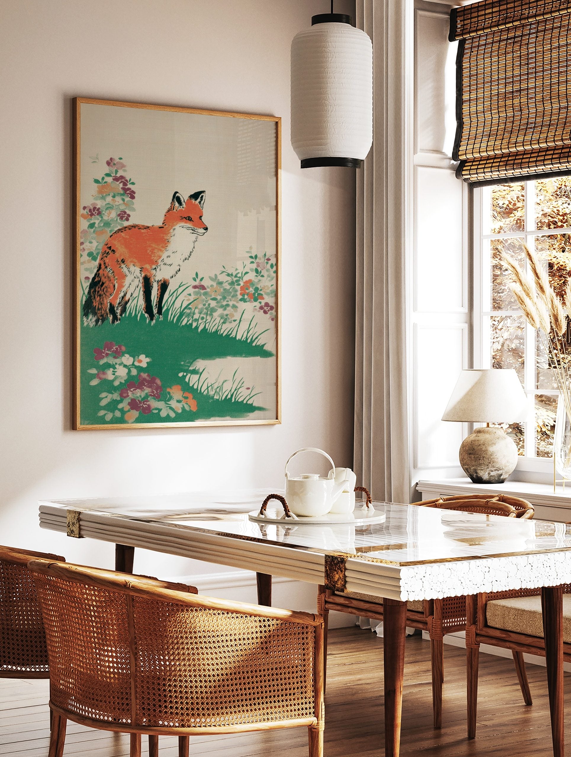 Illustrative print of an orange fox standing in green grass with colourful wildflowers on a beige, in a styled room mockup