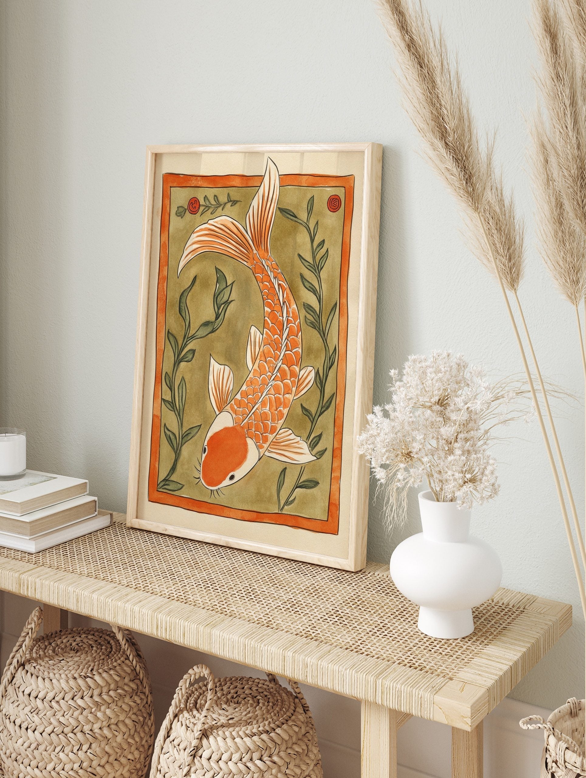 Orange koi fish illustration with white accents, swimming amidst green aquatic plants within, in an alternate framed mockup