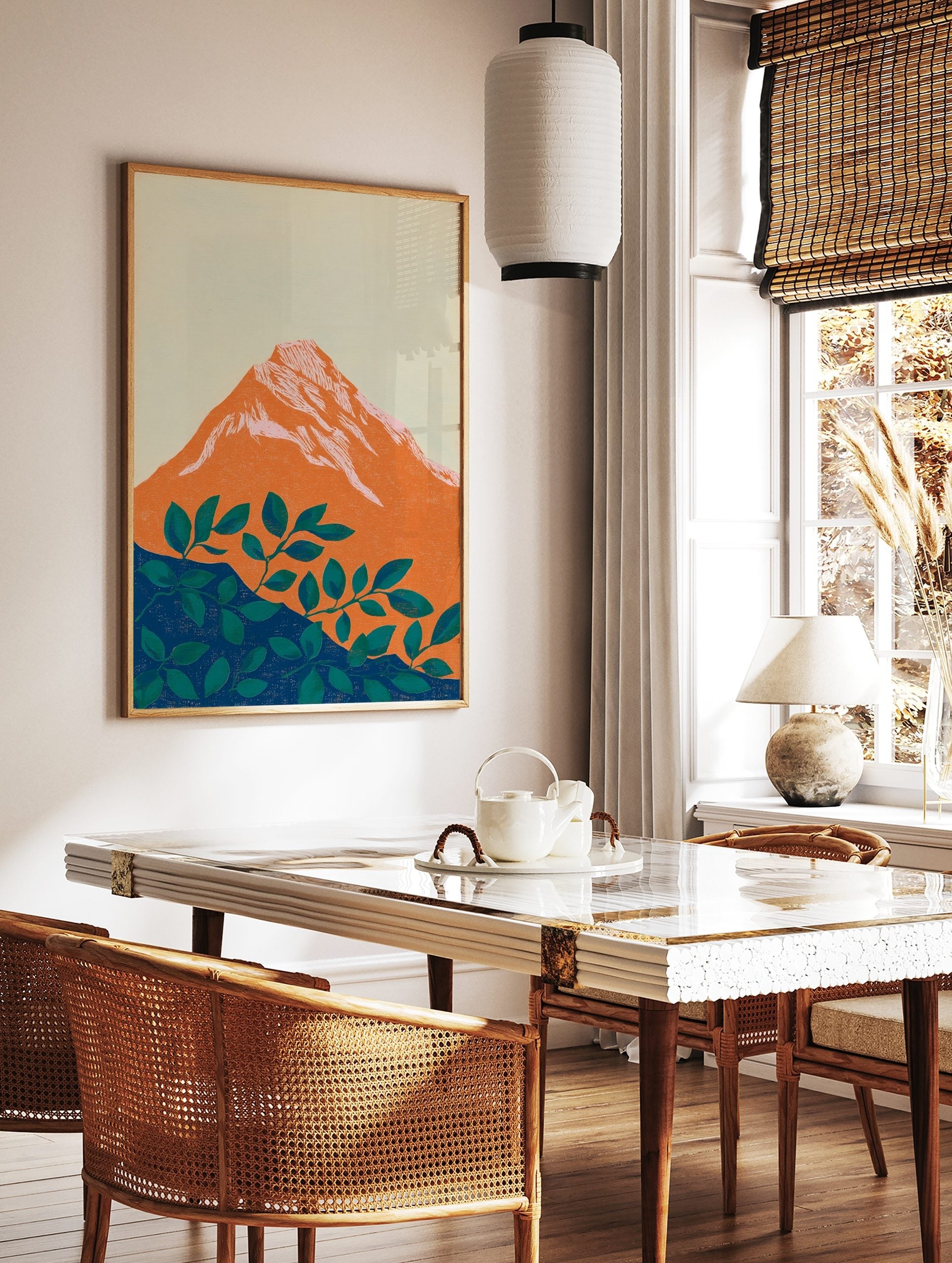 Stylised orange mountain with pink-white peaks and green foliage on a deep blue base, set against a, in a styled room mockup