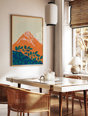 Stylised orange mountain with pink-white peaks and green foliage on a deep blue base, set against a, in a styled room mockup