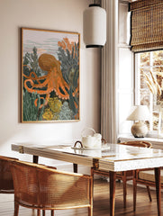 Illustrative orange octopus surrounded by green and yellow underwater plants, with a light grey, in a styled room mockup