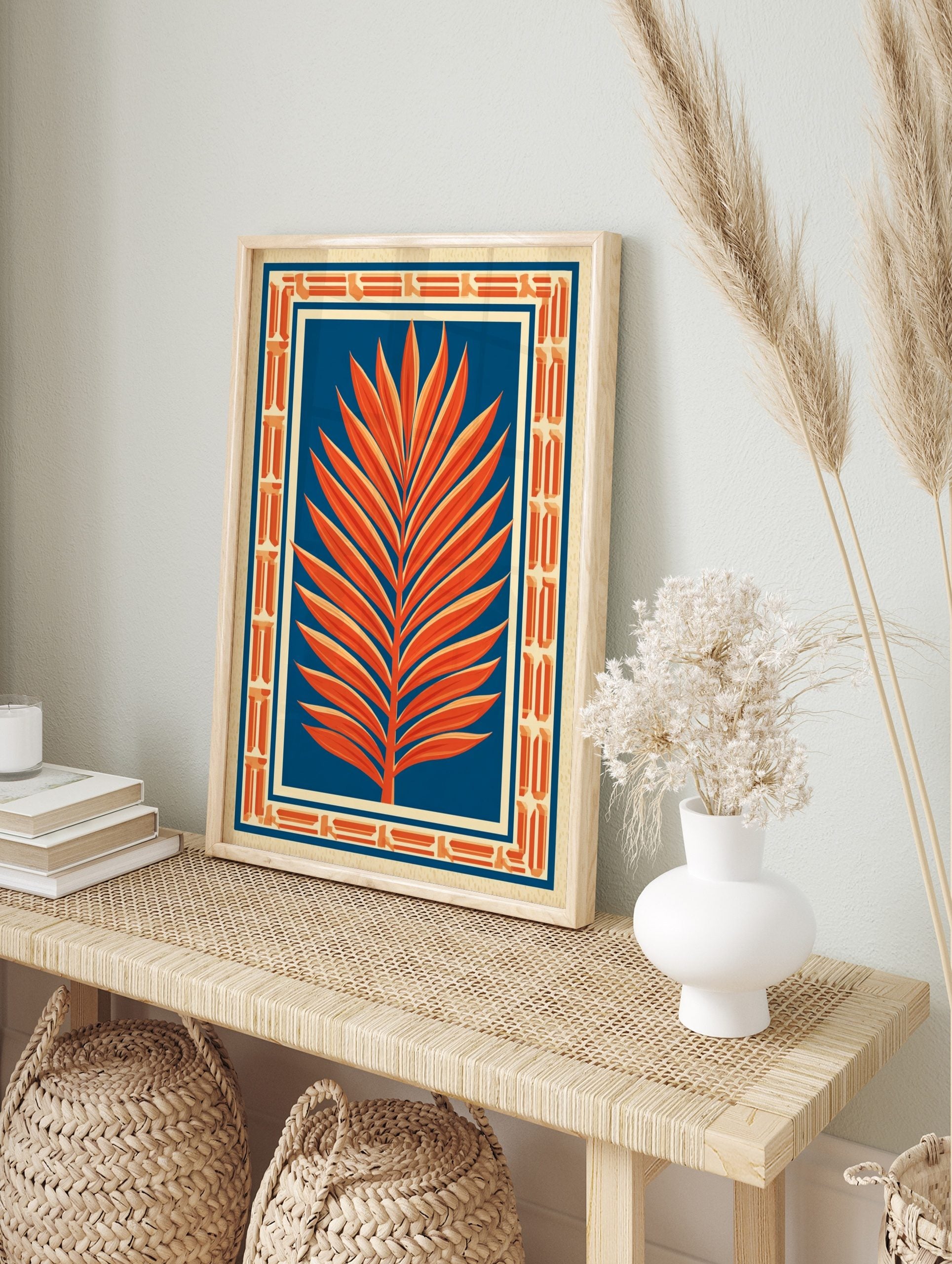 Orange palm leaf illustration against deep blue background with Art Deco geometric border on, in an alternate framed mockup