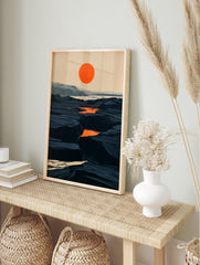 Minimalist landscape art print with a bold orange sun over a dark, rocky canyon terrain in, in an alternate framed mockup