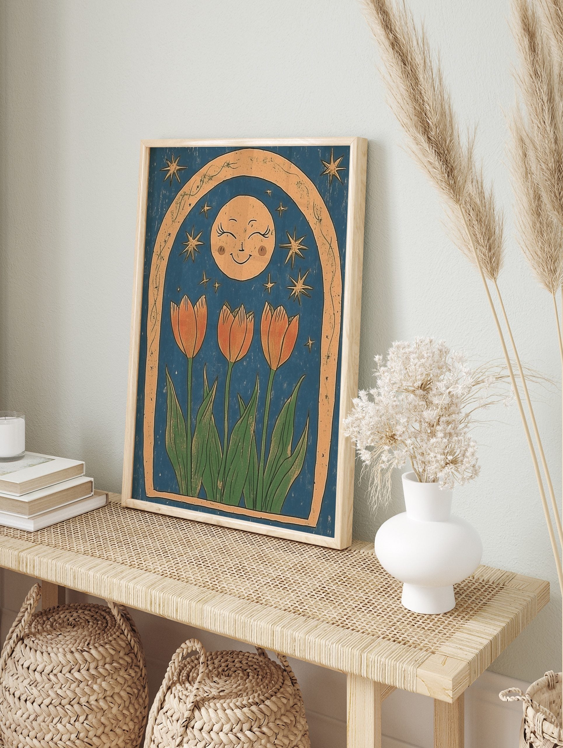 Illustrative print of three orange tulips, a smiling moon, and stars within a textured arch, in an alternate framed mockup