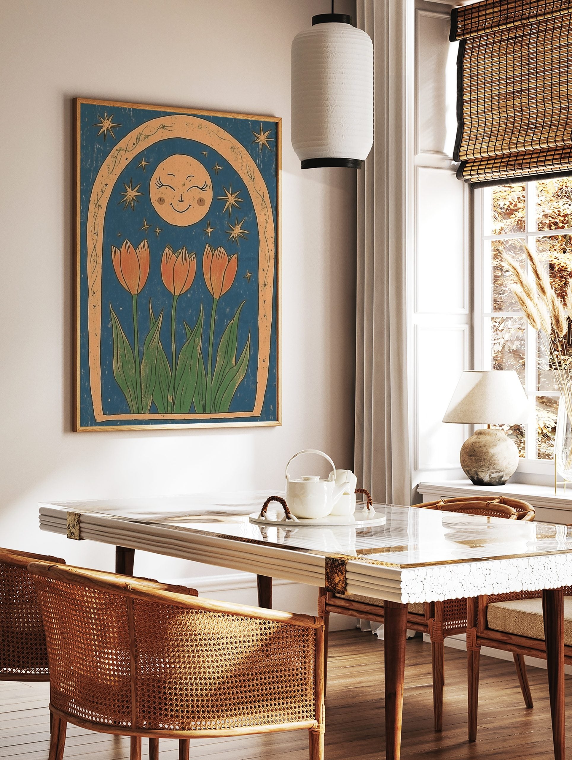 Illustrative print of three orange tulips, a smiling moon, and stars within a textured arch on a, in a styled room mockup