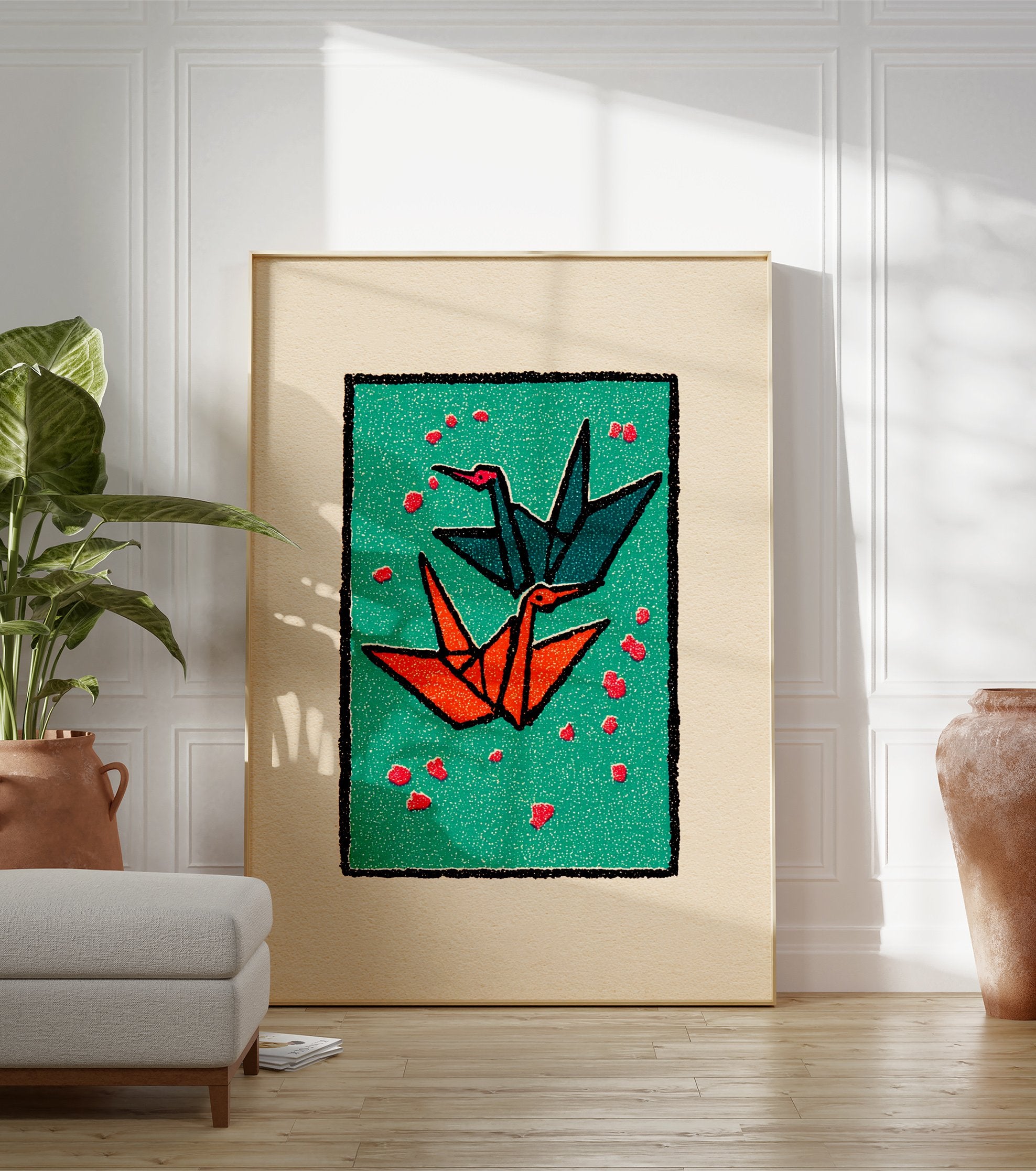 Two origami cranes, one teal and one orange, flying on a green background with red petals, framed by black and cream borders. - Image 3