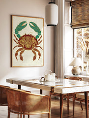 Ornate crab illustration wall art print with gold patterns on a red body and teal claws, on a cream, in a styled room mockup