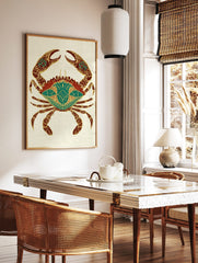 Ornate crab illustration with gold patterns on red and teal body on a light textured background, in a styled room mockup