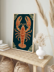 Ornate red-orange lobster illustration with gold details on dark teal background, portrait, in an alternate framed mockup
