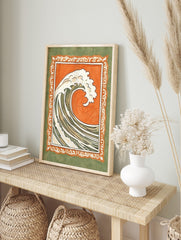 Stylised ocean wave illustration with white foam, orange background, and ornate green border, in an alternate framed mockup