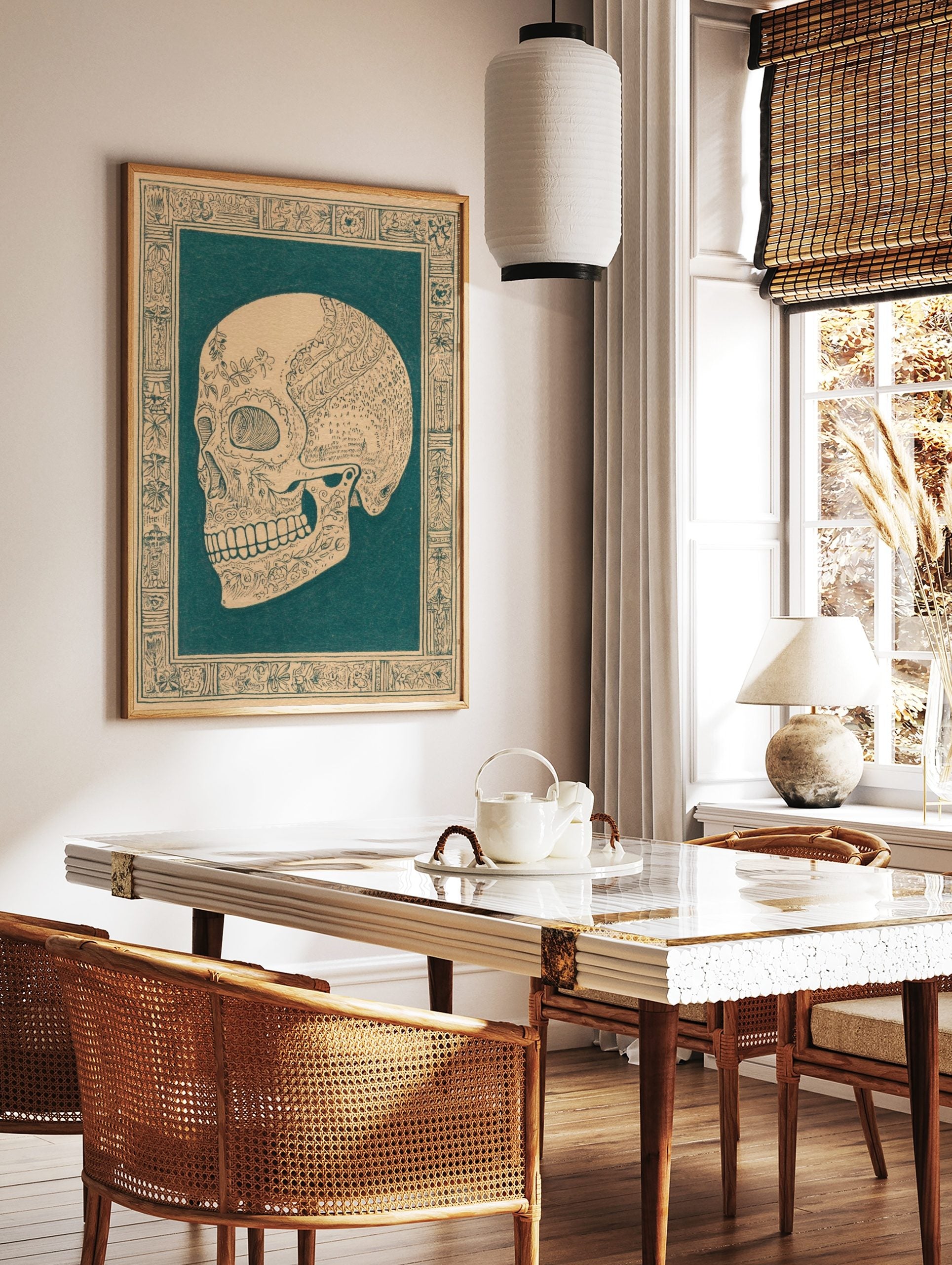 Ornate skull illustration in dark teal on beige, with intricate floral patterns and decorative, in a styled room mockup