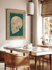 Ornate skull illustration in dark teal on beige, with intricate floral patterns and decorative, in a styled room mockup