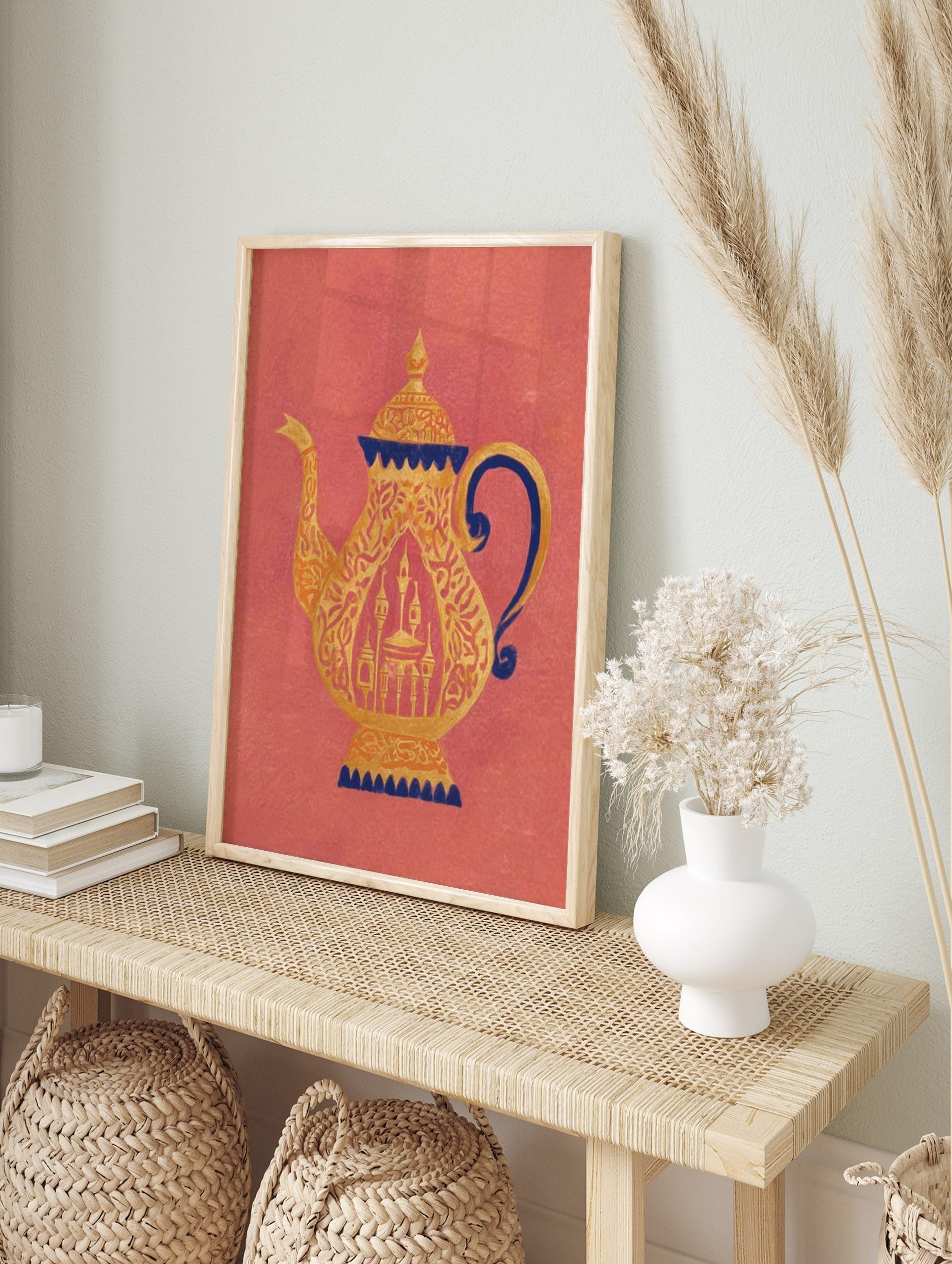 Ornate golden teapot with dark blue accents and intricate patterns on a coral background, in an alternate framed mockup