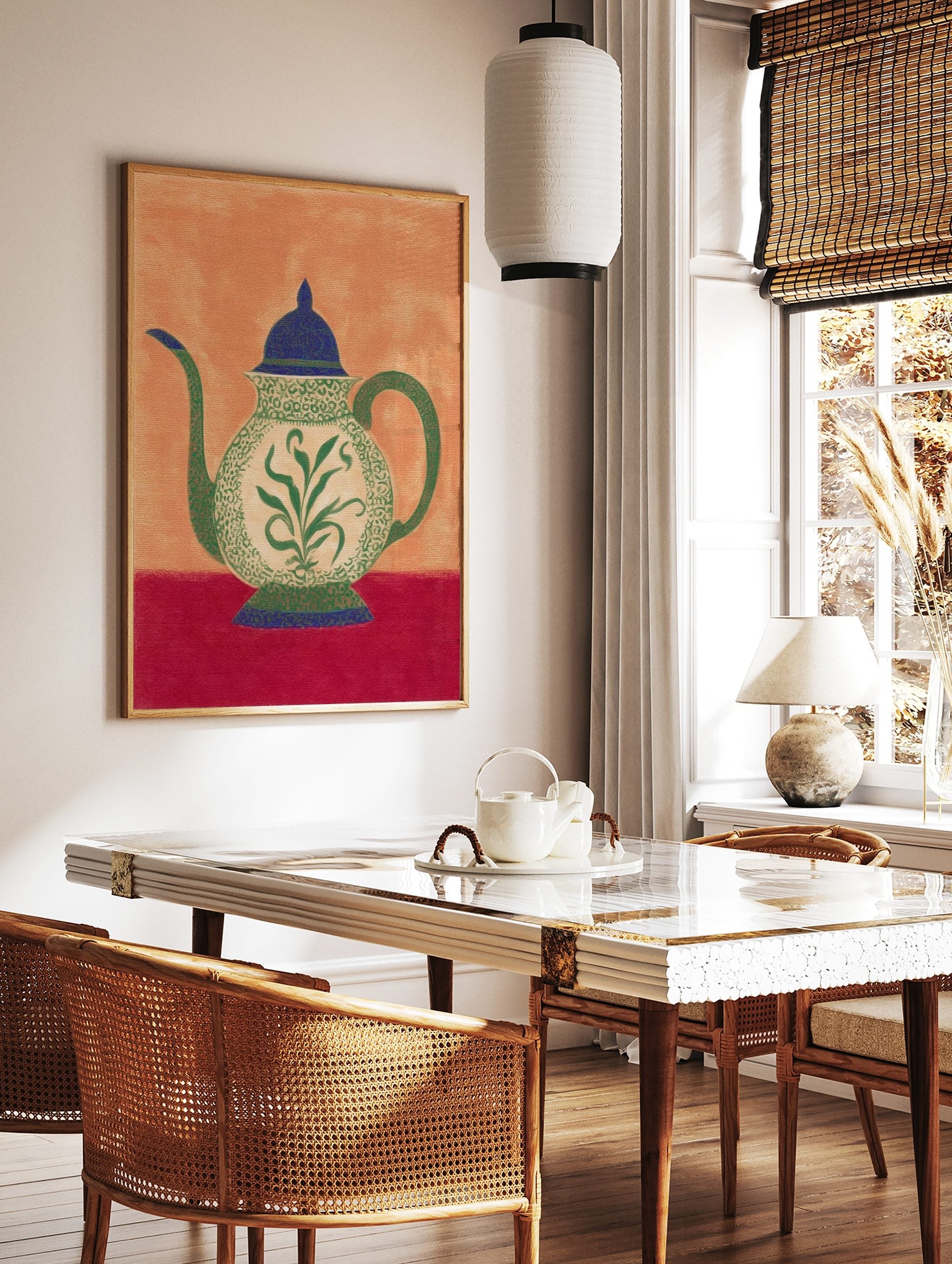 Ornate teapot illustration with green botanical pattern, blue lid, and red table on an orange, in a styled room mockup