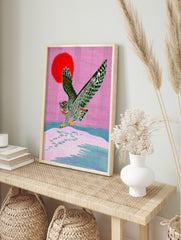 Illustrative grey owl landing on snow with red sun and pink sky art print, in an alternate framed mockup