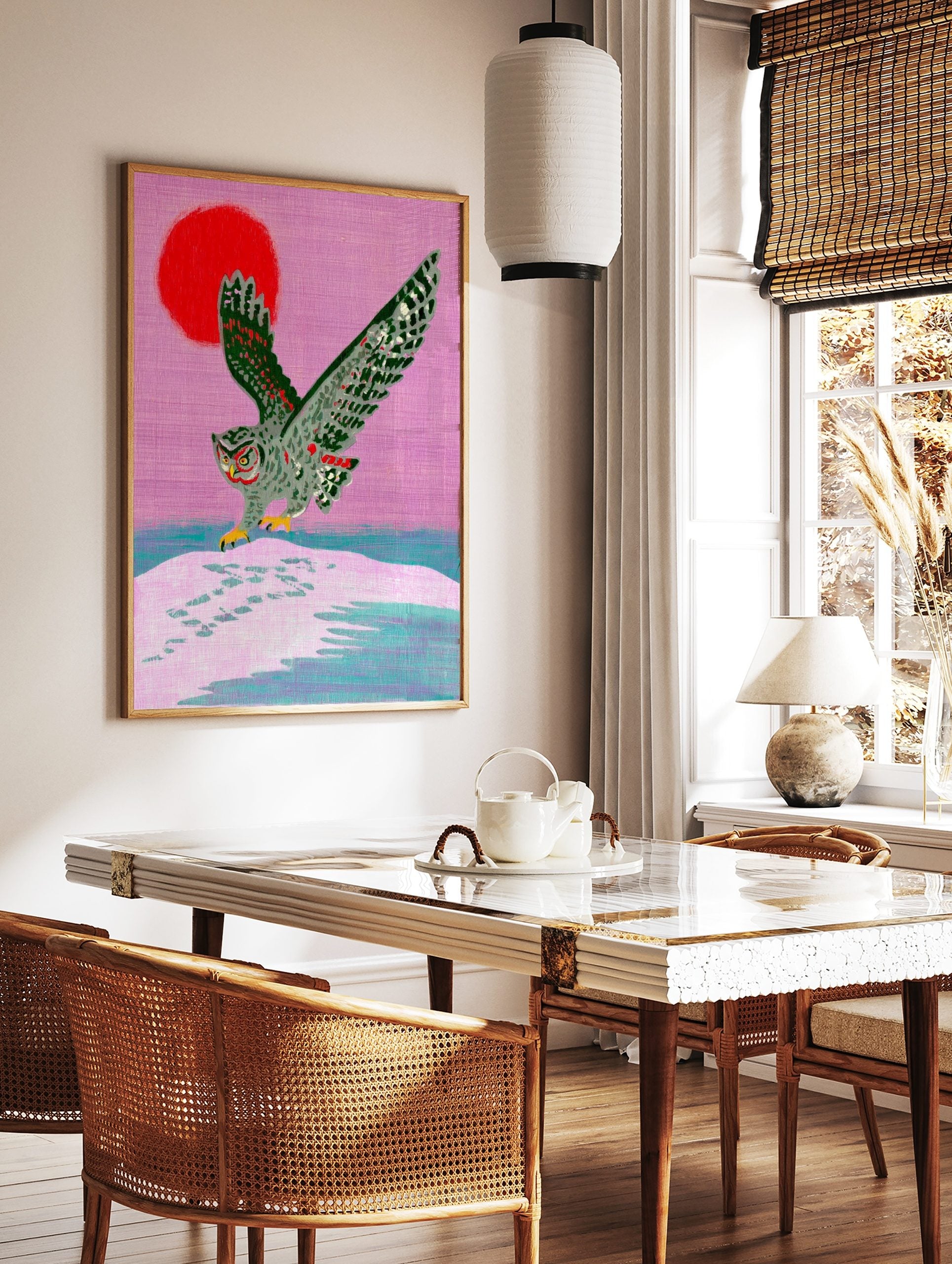 Illustrative grey owl landing on snow with red sun and pink sky art print, in a styled room mockup