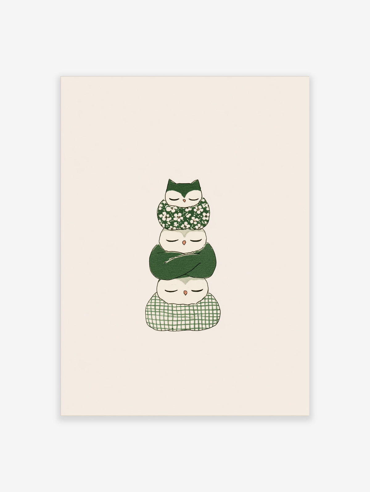 Stack of three sleeping owls in green floral, solid, and checked wraps on beige background