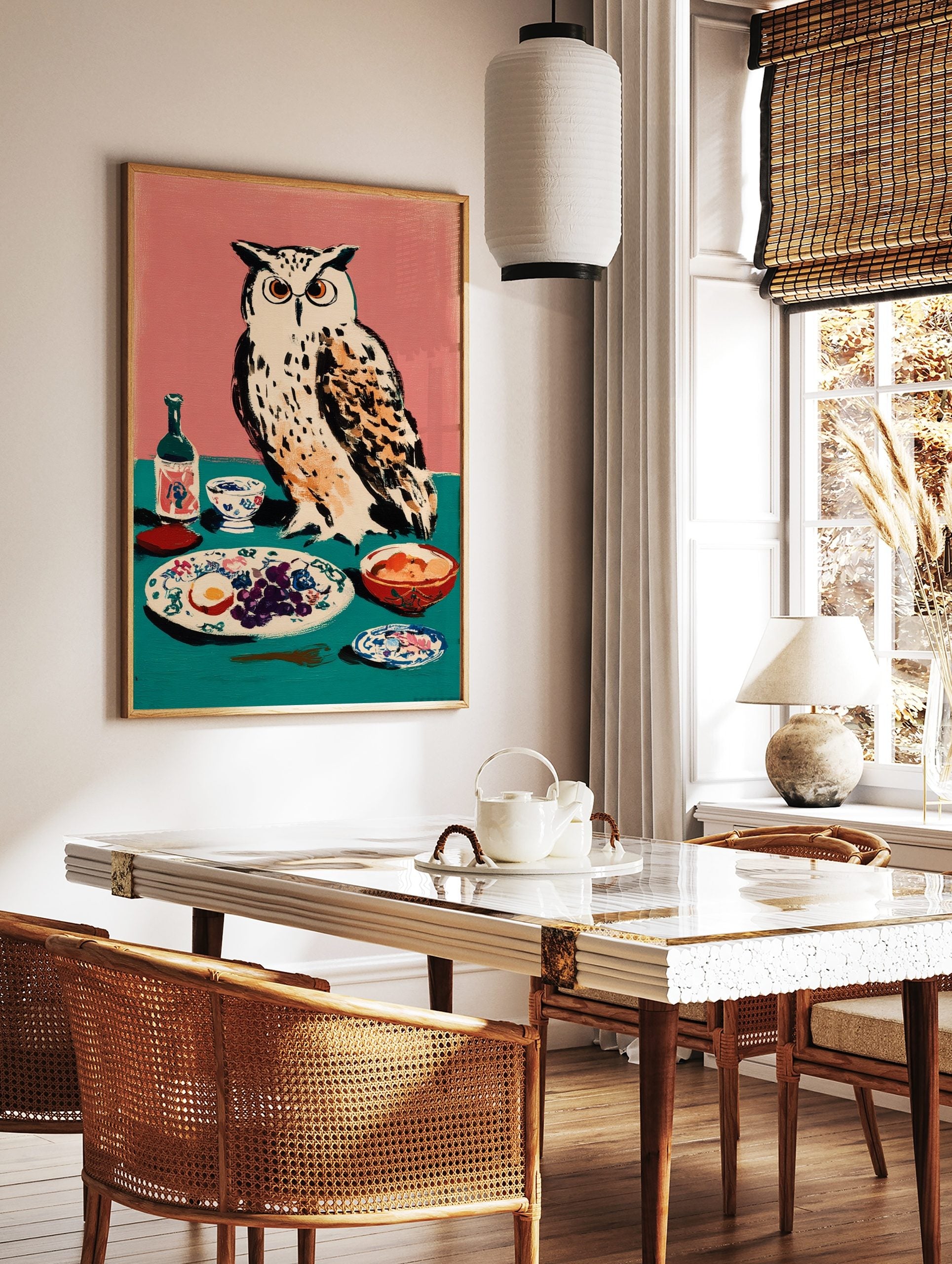 Illustrative art print of a white owl with orange eyes next to a table with grapes, egg, and a, in a styled room mockup