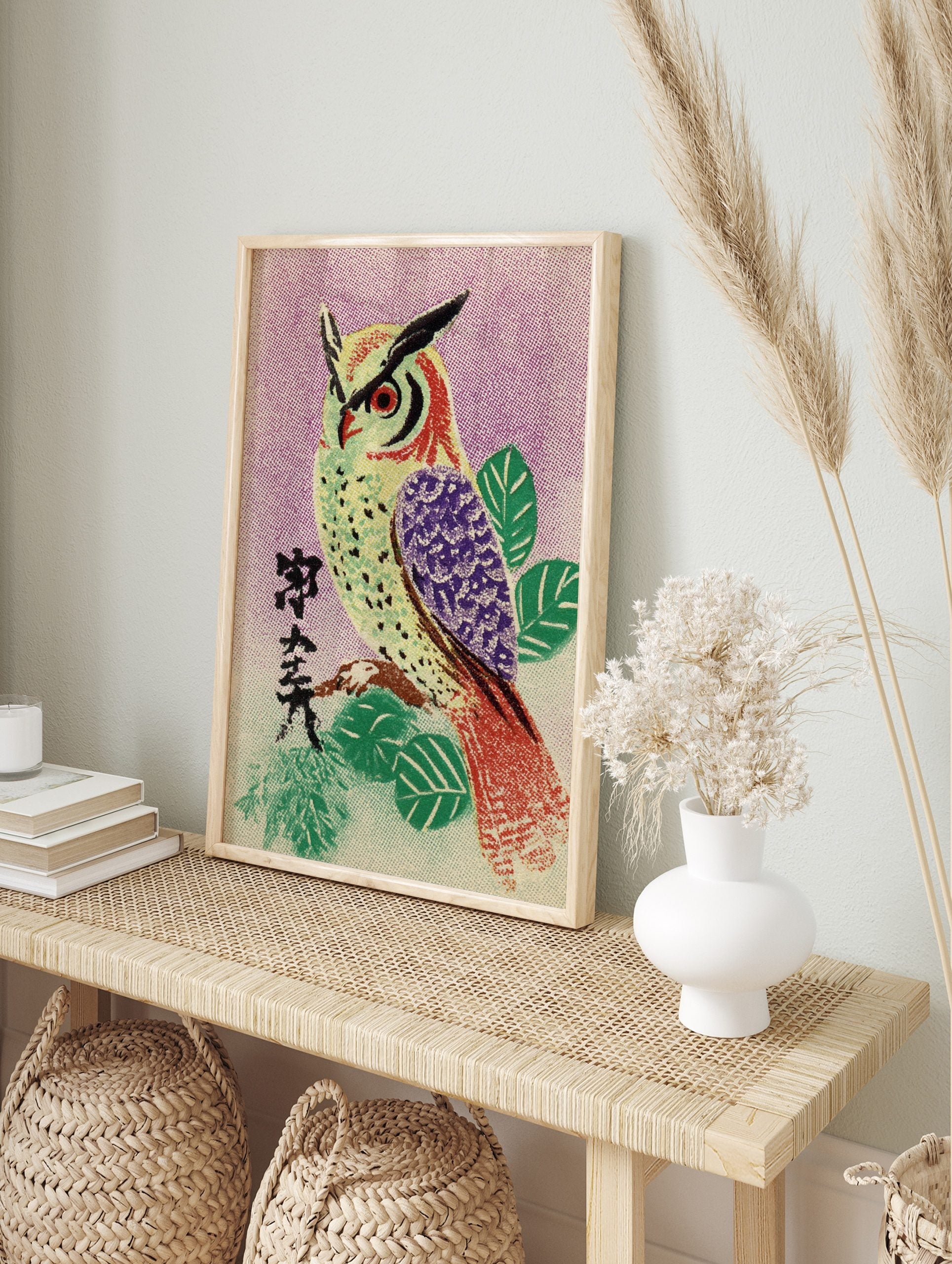 Illustrative owl with red eyes and purple wing on branch, Japanese characters, purple, in an alternate framed mockup