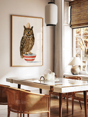Watercolour illustration of a great horned owl balancing an egg on its head whilst standing in a, in a styled room mockup