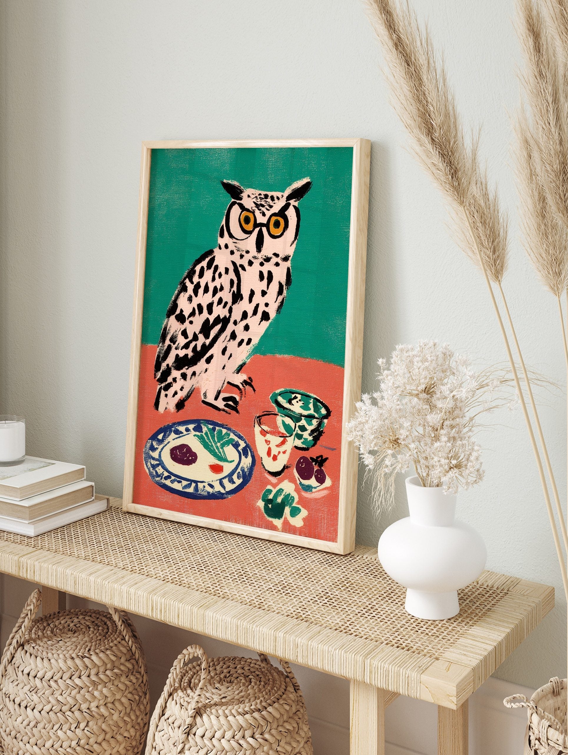 Illustrative owl wall art with yellow glasses at a dinner table, against a teal and coral, in an alternate framed mockup