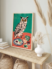 Illustrative owl wall art with yellow glasses at a dinner table, against a teal and coral, in an alternate framed mockup
