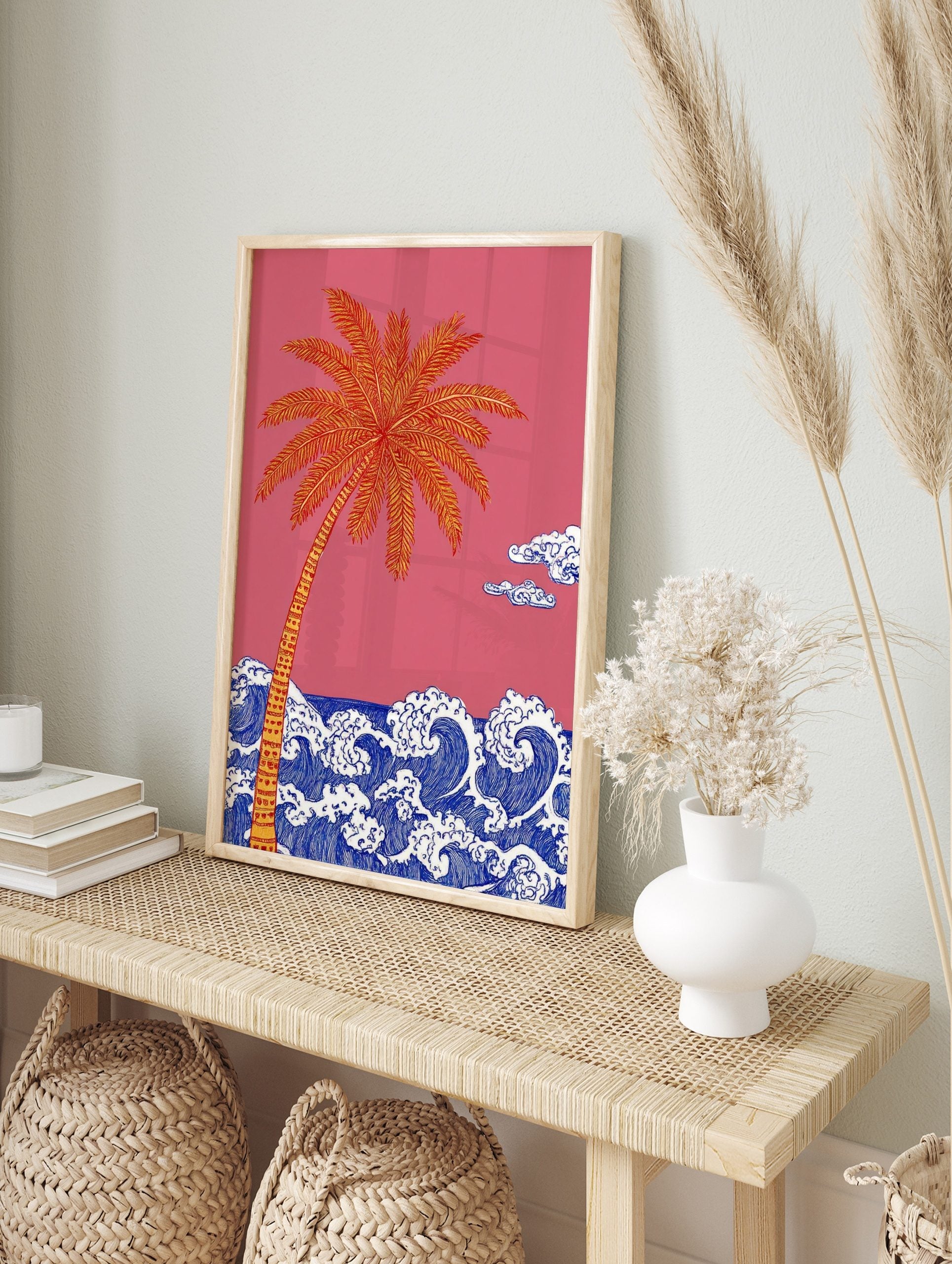 Illustrative palm tree with orange and yellow fronds over blue ocean waves against a pink sky, in an alternate framed mockup