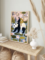 Illustrative art print of a black and white panda with a golden monkey on its back, walking, in an alternate framed mockup