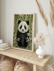 Linocut style illustration of a giant panda sitting among green bamboo stalks and leaves, in an alternate framed mockup