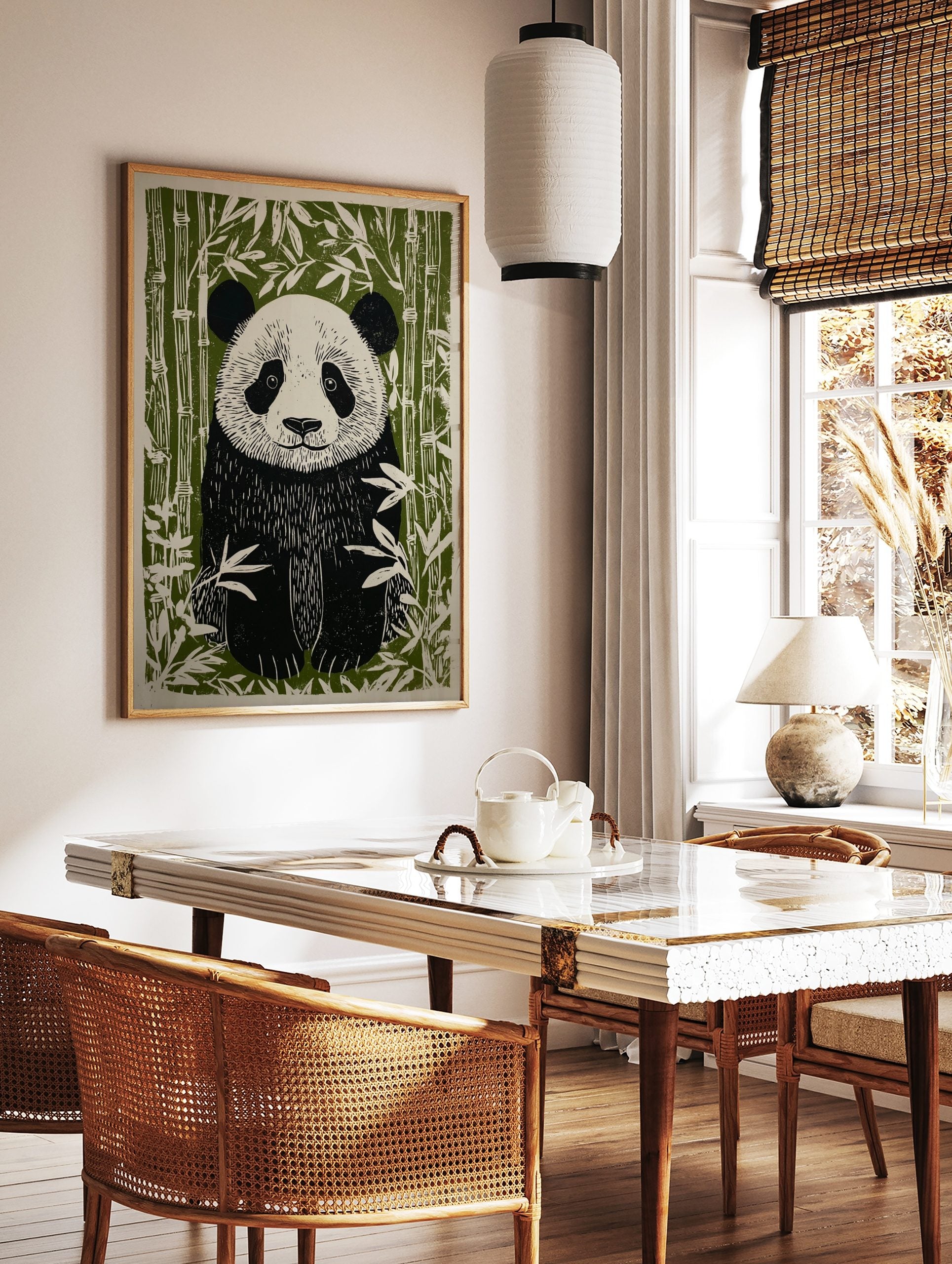 Linocut-style illustration of a black and white panda with green bamboo stalks and leaves, in a styled room mockup
