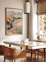 Painterly landscape art print of a pastoral valley with rolling hills, trees, and many grazing sheep, in a styled room mockup